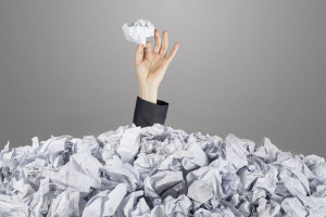 Hand with piece of paper from pile of paper